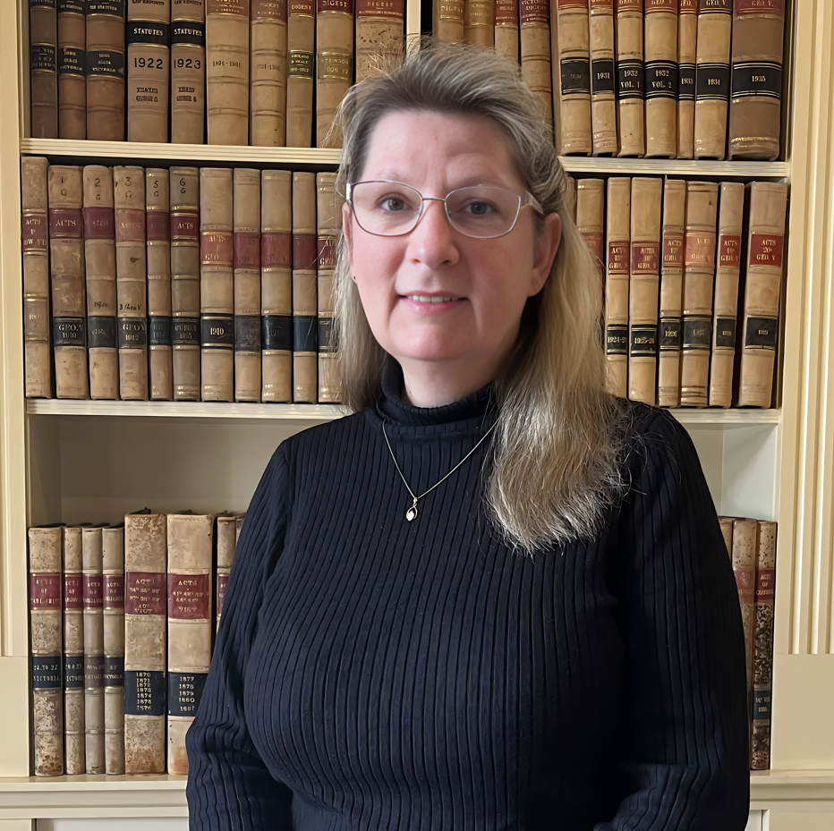 Woman in black sweater, books behind