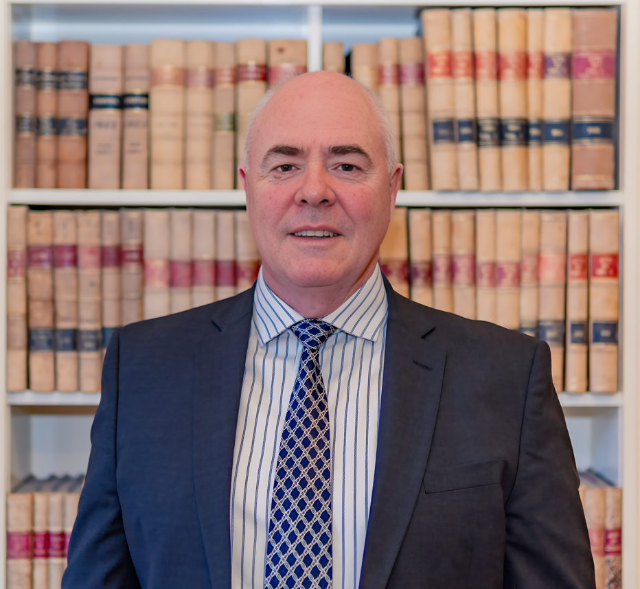 Man in suit, books in background